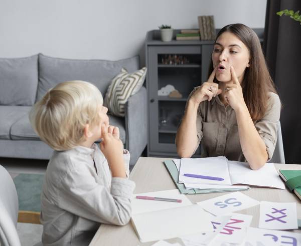 a woman and a young boy sitting at a dining table